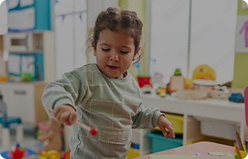 A young girl plays with toys in a classroom
