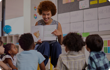 A teacher reads a book to small children sitting on the floor