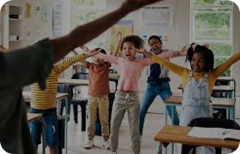Children in a class with their arms stretched out following after their teacher. They are happy.