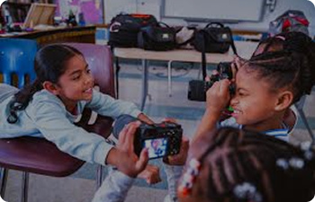 Three children using a camera.