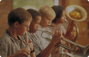 A line of 5 children playing brass instruments