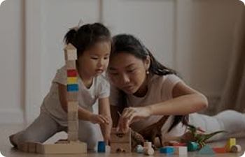 A young women and toddler play with blocks together.